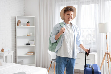 Male tourist with bags and passport in hotel room