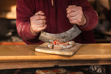 Holiday Delicacy: Hands Cutting Wood Oven Bread at Christmas Market