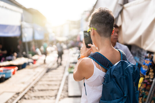 Woman taking photos at Maeklong market.