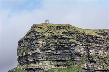 Cliff with a small white tower on the top