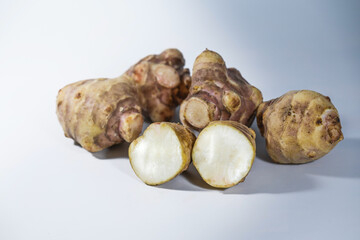 Jerusalem artichoke or topinambur (Helianthus tuberosus), species of sunflower used as root vegetable, rich in inulin and therefor recommended for diabetes, gray background, copy space - 777745253