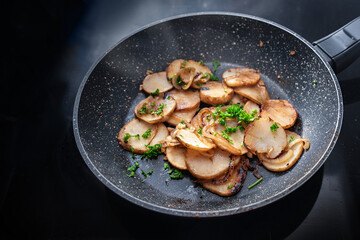 Roasted Jerusalem artichoke or topinambur (Helianthus tuberosus) with onions and parsley in a...