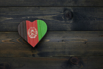 wooden heart with national flag of afghanistan on the wooden background.