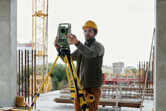 Construction Worker Adjusting Theodolite