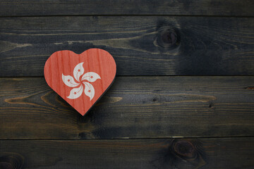 wooden heart with national flag of hong kong on the wooden background.