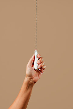 man flushing the toilet by pulling the cistern chain