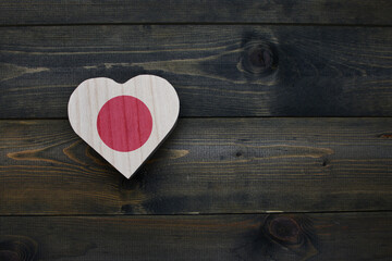 wooden heart with national flag of japan on the wooden background.