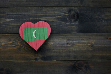 wooden heart with national flag of maldives on the wooden background.