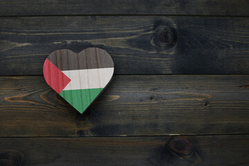 wooden heart with national flag of palestine on the wooden background.