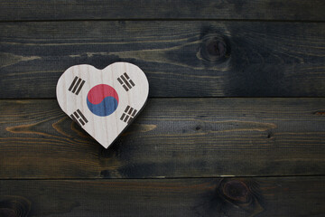 wooden heart with national flag of south korea on the wooden background.