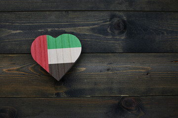 wooden heart with national flag of united arab emirates on the wooden background.