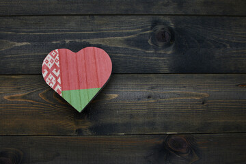 wooden heart with national flag of belarus on the wooden background.