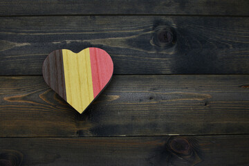 wooden heart with national flag of belgium on the wooden background.