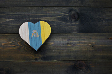 wooden heart with national flag of canary islands on the wooden background.
