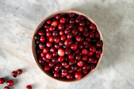 Just harvested cranberries in bowl on marble table