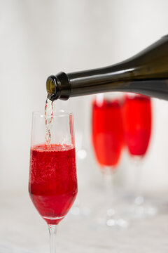 Drinks: Cranberry-rosemary prosecco cocktail. Pouring alcohol.