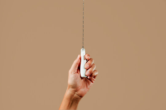 flushes the toilet by pulling the chain