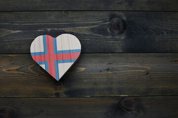 wooden heart with national flag of faroe islands on the wooden background.
