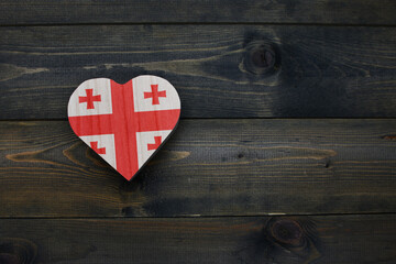 wooden heart with national flag of georgia on the wooden background.