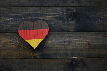 wooden heart with national flag of germany on the wooden background.