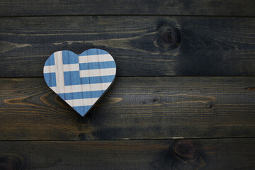wooden heart with national flag of greece on the wooden background.
