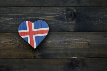 wooden heart with national flag of iceland on the wooden background.