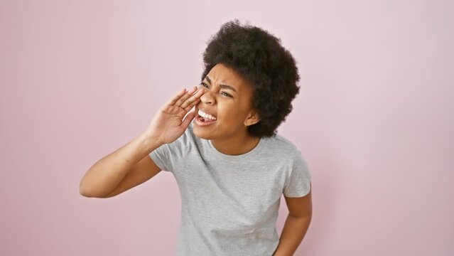 Clueless african american woman in t-shirt, arms raised in doubt and confusion, standing isolated on pink background with 'i don't know' expression