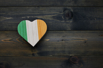 wooden heart with national flag of ireland on the wooden background.