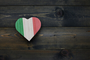 wooden heart with national flag of italy on the wooden background.