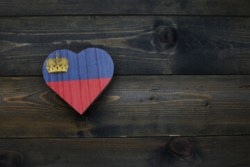 wooden heart with national flag of liechtenstein on the wooden background. - obrazy, fototapety, plakaty
