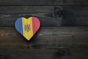 wooden heart with national flag of moldova on the wooden background.