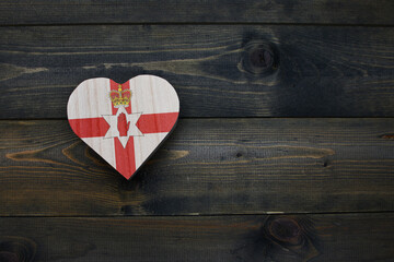 wooden heart with national flag of northern ireland on the wooden background.
