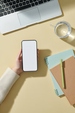 Mockup smartphone on hands, top view office desk.