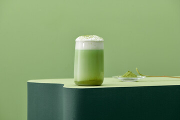 Iced Green matcha tea mixed with ice cube and milk in latte glass