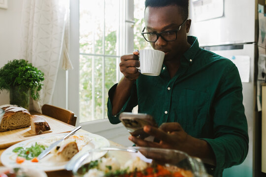 A man with a phone at breakfast time