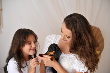 mãe e filha felizes com filhote de cachorro da raça Duchshund , amor em familia 