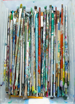 Paintbrushes collection in a box colorful texture background