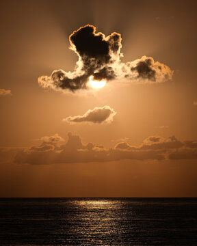 The sun behind some clouds.