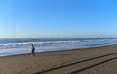 Fisherman on sand beach during windy summer day on pacific ocean (Iloca, Chile)
