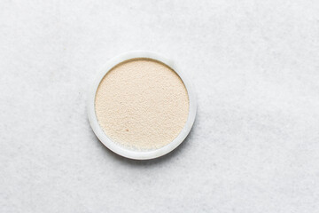 Overhead view of instant yeast on a white tray, yeast granules for baking bread