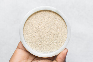 Overhead view of instant yeast on a white tray, yeast granules for baking bread