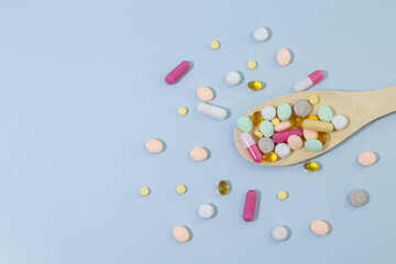 Scattered white pills on blue table. Mock up for special offers.