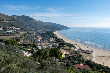 View on sandy beach from hilly medieval small touristic coastal town Sperlonga and sea shore, Latina, Italy