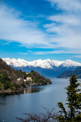 Fototapeta na wymiar Driving car along shores of Lake Como in Northern Italy, spring sunny days, views of alpine mountains, water and villages