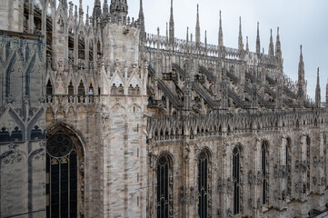 Architectural details of Gothic cathedral church in Milan, tourist attraction in northern Italy - obrazy, fototapety, plakaty