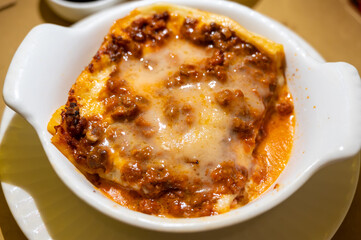 Traditional first course for lunch or dinner in Italy, lasagne Bolognese with beef meat and bechamel sauce served in Italian restaurant, Milan, Italy