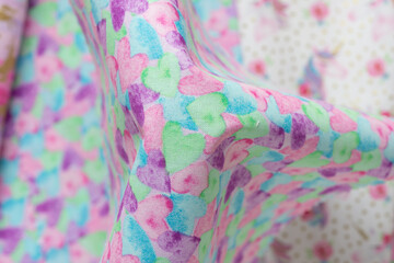 close-up of decorative material with heart prints and defocused material with unicorns