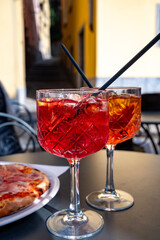 Aperol and Campari Spritz orange bitter long drink cocktails made with liqueur, prosecco sparkling wine, ice cubes and piece of orange, Milan, Italy