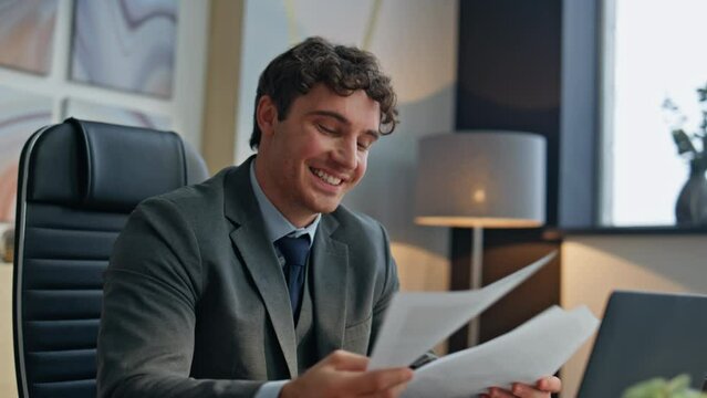 Happy boss speaking web conference in office closeup. Smiling man showing papers