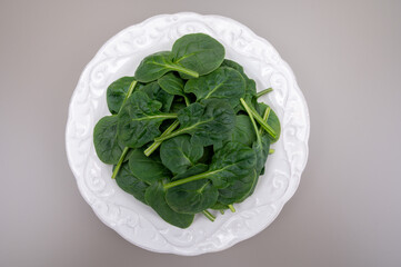 Fresh green baby Spinach leaves, diet and health concept, weight loss, spinach on ceramic plate,...